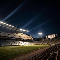 Night view of an empty football stadium under a starry sky with bright stadium lights illuminating the stands and field photo