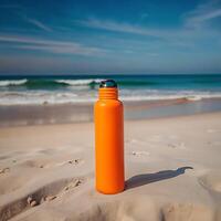 A vibrant orange water bottle stands on a pristine beach with a breathtaking ocean view on a sunny day photo