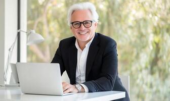 Mature man working on laptop in office photo