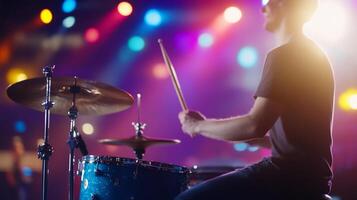 Drummer playing drums on stage with lights photo