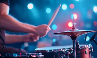Drummer playing drums on stage with bright lights. photo