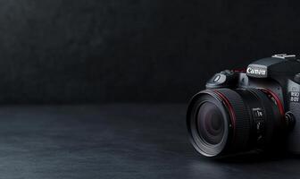 DSLR camera with lens on dark surface. photo