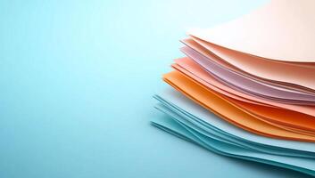 Stack of pastel colored papers on blue background. photo