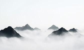 Misty mountain range peaks emerging from clouds. photo