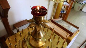a golden candle holder with a red candle on top photo