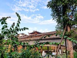 China, LeShan, 01.01.2025 a bridge over a river with a clock tower in the background photo