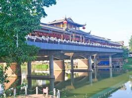 China, LeShan, 01.01.2025 a bridge over a river with a chinese building in the background photo