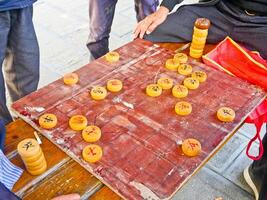 a man playing a game of chinese checkers on a wooden table photo