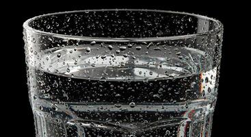 Close-up of a Glass of Water with Condensation Droplets on a Black Background A Refreshing Image photo