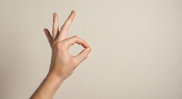 A Close-up Shot of a Hand Forming the Okay Sign Against a Neutral Background A Simple Gesture of Approval and Agreement photo