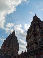 Yogyakarta - Indonesia, July 30, 2024 A majestic view of the Prambanan temple complex with its towering spires against a backdrop of a blue sky and fluffy clouds. photo