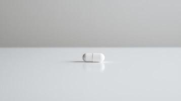White capsule resting on a smooth surface in a minimalist setting during daylight photo