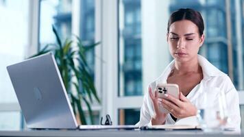 Beautiful concentrated business woman Working on Computer, using smartphone in a Modern Bright Office. Managing Company Operations, Analysing Statistics, Commerce Data, Marketing Plans video