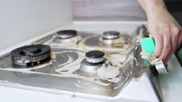 Cleaning a stovetop for a fresh look. Person is scrubbing a stovetop, removing grease and dirt with a cloth while maintaining a clean kitchen environment. video
