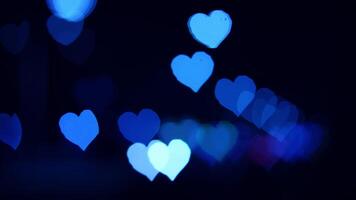 Glowing blue hearts at night. Glowing blue heart shapes illuminate a dark background, creating a romantic and enchanting atmosphere in the evening. video