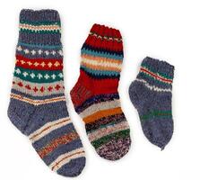 Knitted socks set. Warm winter woolen multi-colored sock with handmade ornament. Vintage knitting isolated on a white background. photo