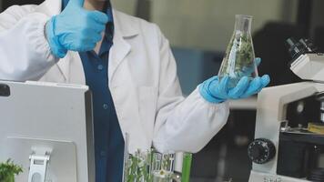 A man in a lab coat is holding up a glass of water video