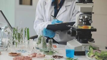 A woman in a lab coat is looking at a microscope video
