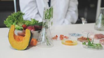 A person in a lab coat is standing in front of a table with various food items video