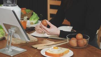 A woman is using a tablet to make an order video