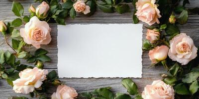 Elegant floral arrangement with blank paper surrounded by roses on wooden surface for event invitation design photo