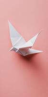 Delicate origami swallow crafted from white paper on pastel background photo