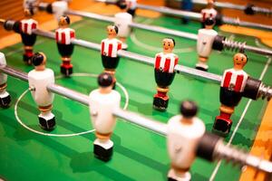 Tabletop football game with red and white player figures on green field photo