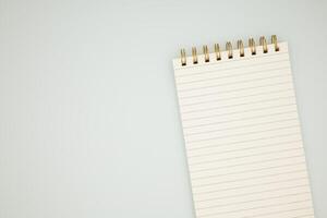 Spiral notepad with blank lined pages on light background photo