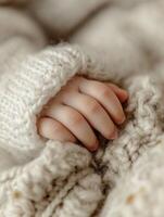 Tender moment. Babys tiny hand resting on soft woolen fabric photo