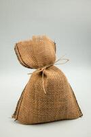 Rustic burlap sack with string tie on neutral background photo