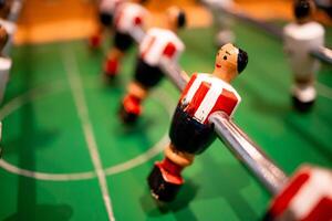 Close up of table foosball game with player figurines on green field photo