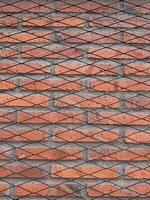 Textured red brick wall with black diagonal patterns for background design photo