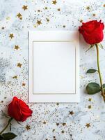 Elegant flat lay of a white greeting card with red roses and gold stars on marble background photo