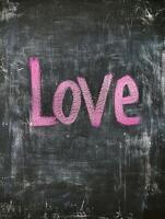 Love message in bright pink chalk on blackboard for romantic designs photo