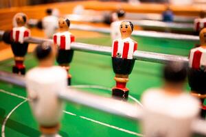 Table soccer game close up with red and white team figures on green field photo