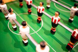 Table soccer game with colorful players on green field photo