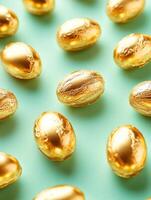 Easter celebration with tiny golden chocolate eggs on turquoise background photo