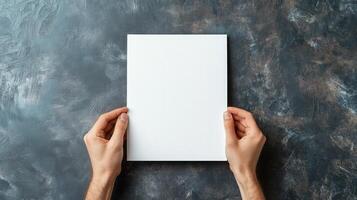 Hands Holding Blank White Paper on Dark Background photo