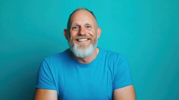 Happy mature man smiling against a blue background photo
