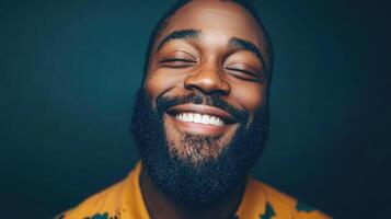 A smiling man with eyes closed and a beard photo