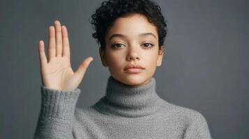 Young woman displays a raised hand in refusal photo