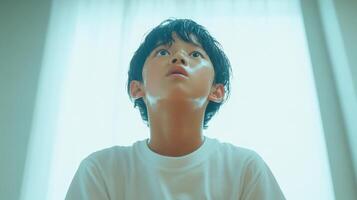 Sweaty Boy Looking Upwards Towards Light photo