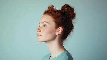 Red haired girl profile view with messy bun photo