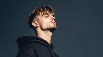 Young Man in Black Hoodie Contemplating Outdoors photo
