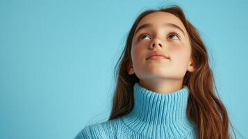 Young Girl Looking Upward Wearing a Blue Sweater photo