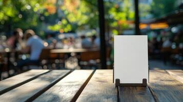 Blank sign stands on wooden table outside cafe photo