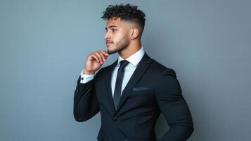 Young Man in Black Suit Contemplating Thoughtfully photo