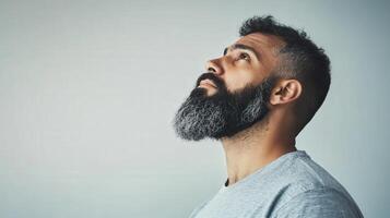 A Man With A Beard Looks Upward Contemplatively photo