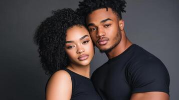 A Young Couple Poses Closely Together In Black Attire photo