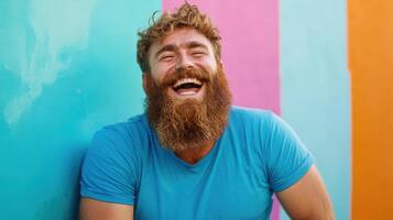 Happy Man with Red Beard Laughing Against Colorful Wall photo